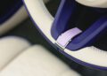 Close-up of a Bentley Continental GTC Speed steering wheel with Violette cream and purple leather detailing and visible stitching.