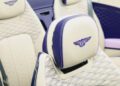Close-up of a cream and Violette color car seat headrest with the Bentley logo stitched in blue, surrounded by matching luxury leather interior—crafted exclusively for the Continental GTC Speed.