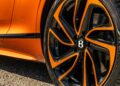 Close-up of a Bentley car's orange and black alloy wheel with a Pirelli tire, showcasing the First Ombré by Mulliner Collection arriving at Bentley Rancho Mirage with three bespoke commissions and part of the striking orange body.