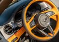 Close-up view of a Bentley car interior, highlighting the two-tone leather steering wheel, dashboard controls, and air vent—showcasing details inspired by the First Ombré by Mulliner Collection arriving at Bentley Rancho Mirage with three bespoke commissions.