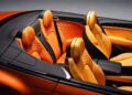 Close-up view of a luxury convertible car interior featuring orange leather seats with diamond stitching and black trim—part of the First Ombré by Mulliner Collection arriving at Bentley Rancho Mirage with three bespoke commissions.