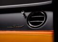 Close-up of a car's interior showing a circular air vent, chrome detailing, and a "Speed" emblem above orange and yellow leather upholstery—part of the First Ombré by Mulliner Collection arriving at Bentley Rancho Mirage with three bespoke commissions.