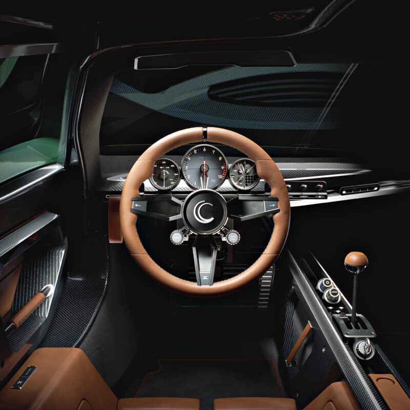 A modern car interior featuring a brown and black leather steering wheel, multiple analog gauges, and a central console with various controls evokes the spirit of Zagato’s First Hypercar: How the Capricorn 01 Redefines Analog Performance.