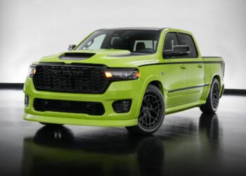 A bright green, modern pickup truck with black wheels and accents—showcasing Mopar Performance Concepts—is parked indoors on a reflective floor with a neutral background.
