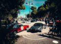 A street scene with classic cars displayed, people walking around, and trees lining the area under a sunny sky during the Modena Cento Ore 25th Anniversary festivities from Oct. 5-10.