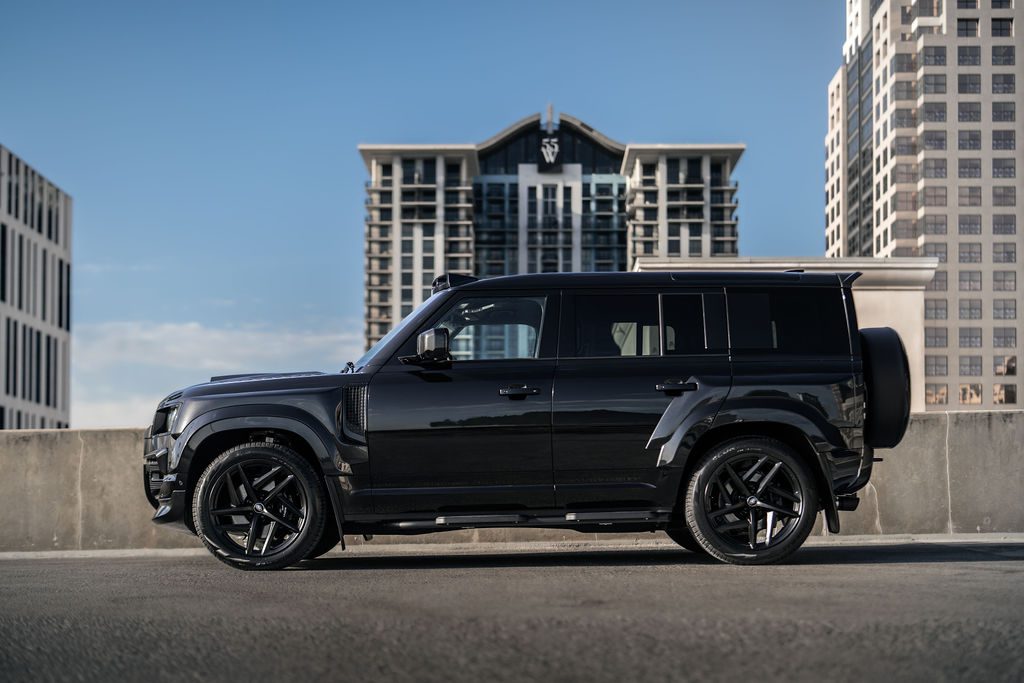 A black SUV from ECD Auto Design parked on a rooftop with modern high-rise buildings in the background under a clear blue sky.