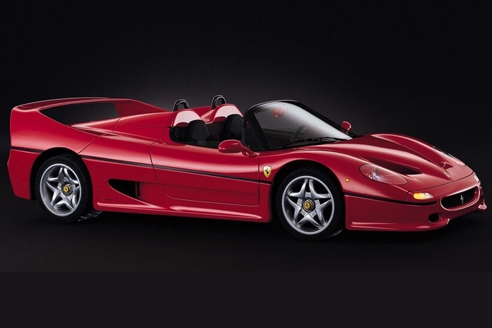 A red convertible sports car with a sleek design and rear spoiler is shown against a black background, evoking the thrilling spirit of classic matchups like Comparison: Ferrari F40 Vs Ferrari F50.