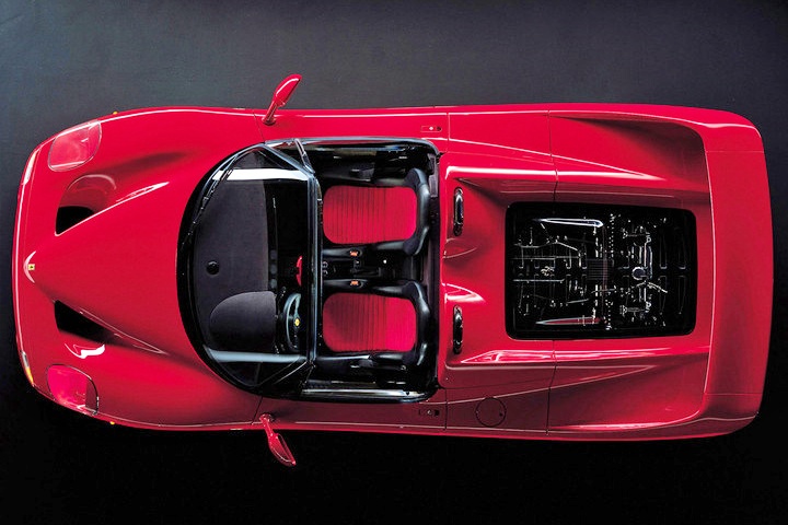 Top view of a red convertible sports car with two seats and a visible rear engine compartment, reminiscent of classic icons in the Comparison: Ferrari F40 Vs Ferrari F50.