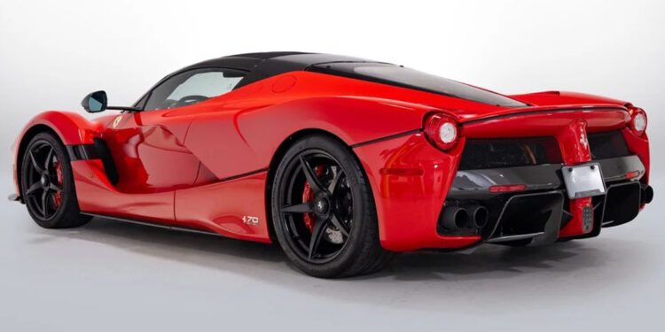 A red sports car with black accents, reminiscent of the Most Expensive Ferraris, is shown from the rear three-quarter angle against a plain white background.