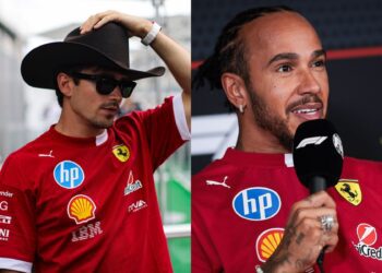Two people wearing red Ferrari team shirts; one adjusts a black cowboy hat and sunglasses, the other speaks into a microphone during an interview.