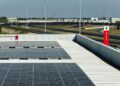 Rooftop solar panels near the e-Vortex Test Track with a red Ferrari sign and industrial buildings in the background.