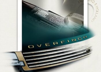 Close-up of a car grille with "OVERFINCH" lettering and part of an engraved firearm, with "Holland & Holland" faintly visible in the background.