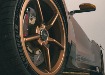 Low-angle close-up of a gold alloy wheel and tire on a Hispano Suiza sports car, highlighting brake calipers and "Michelin Pilot Sport" branding, showcasing the premium engineering of Michelin Tires.