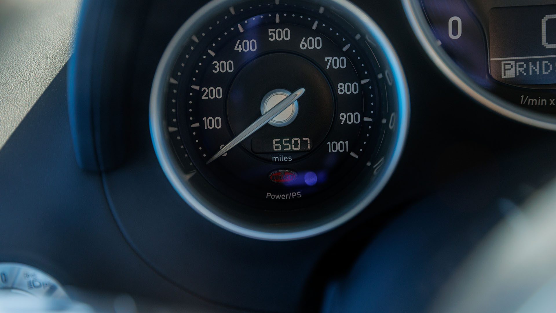 Close-up of a Bugatti Veyron speedometer and odometer showing 6,507 miles—captured ahead of the Broad Arrow auction in Las Vegas 2025.
