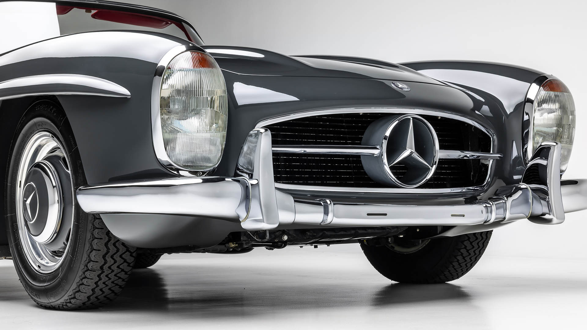 Front close-up of a 2009 Mercedes-Benz SLR McLaren, showing the grille, logo, headlight, and bumper against a white background—an iconic view set to impress at Broad Arrow Las Vegas 2025.