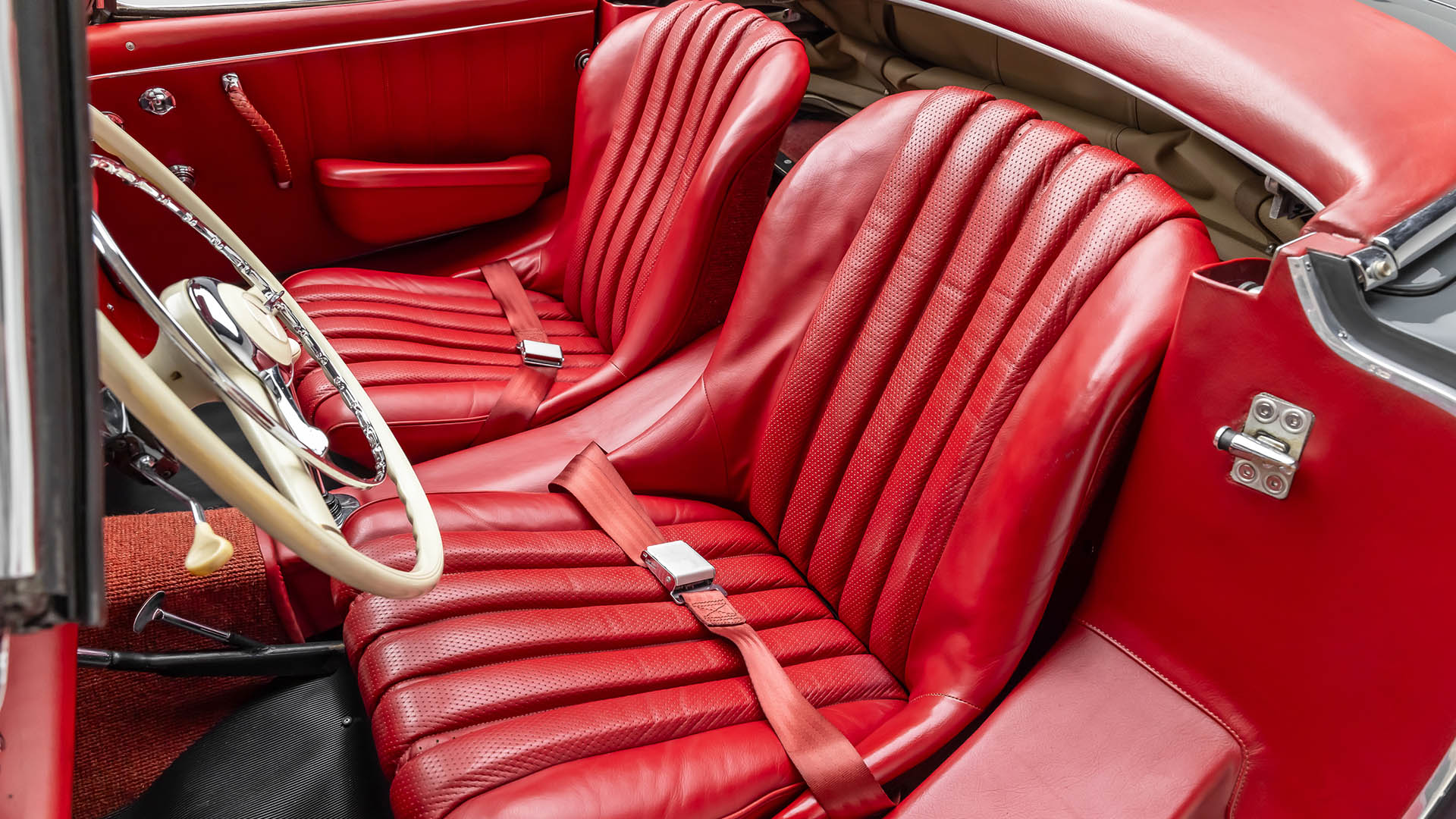 Close-up view of the red leather interior of a 2009 SLR McLaren, showing two front bucket seats, a steering wheel, and part of the door panel—an iconic Mercedes-Benz SLR McLaren highlight perfect for Broad Arrow Las Vegas 2025.