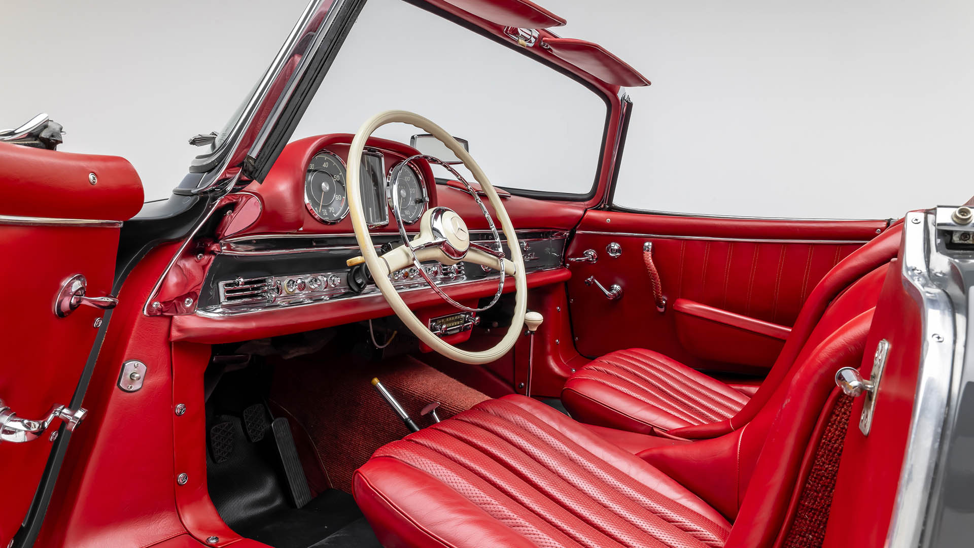 Interior of a classic Mercedes-Benz SLR McLaren convertible featuring red leather seats, a vintage steering wheel, and chrome dashboard detailing. Highlighted at Broad Arrow Las Vegas 2025, this 2009 model exudes timeless elegance.