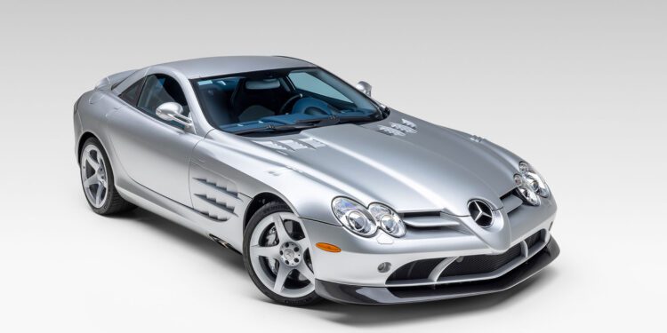 A silver Mercedes-Benz SLR McLaren coupe is parked in a studio with a plain white background, reminiscent of the elegance seen at Broad Arrow’s Las Vegas 2025 event.