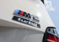 Close-up of a silver "M2 turbo" badge on the rear of a white car, with part of the taillight and blue sky visible—paying homage to the iconic BMW 2002 Turbo with a nod to the 2026 M2 Turbo Design Edition.
