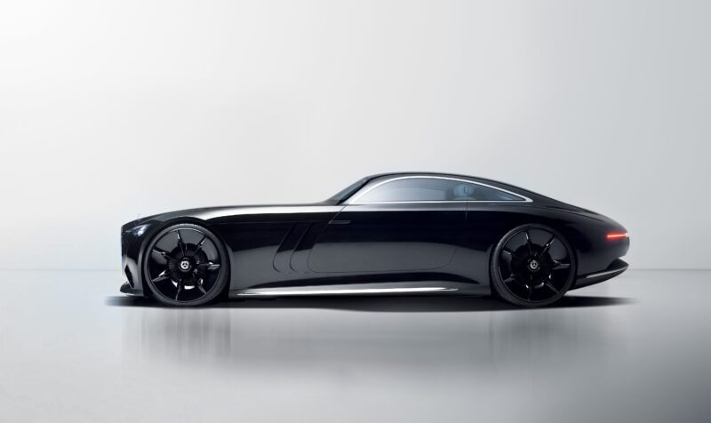 Side view of a sleek, black Mercedes-Benz Vision Iconic coupe with tinted windows and large black wheels, reviving classic elegance for the digital era against a plain light background.