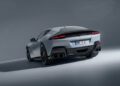 A white Ferrari sports car is shown from the rear in a studio setting, featuring quad exhaust pipes, sleek taillights, and the license plate "MN F1.
