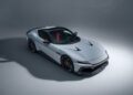 A silver Ferrari 12Cilindri sports car with red interior, featuring sleek NOVITEC customizations, is parked on a seamless grey background, viewed from a high angle.