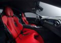 Luxury sports car interior featuring two red leather seats, a black dashboard, center console controls, and a digital display on the passenger side—showcasing exclusive NOVITEC customizations for the Ferrari 12Cilindri.