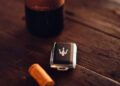 A bottle of Il Bruciato red wine, a wine cork, and a Maserati Grecale Tributo key fob rest elegantly on a wooden surface.