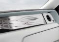 Close-up of a bespoke Rolls-Royce interior, highlighting a decorative silver wave pattern on the dashboard beside an air vent and elegant light-colored leather surfaces.