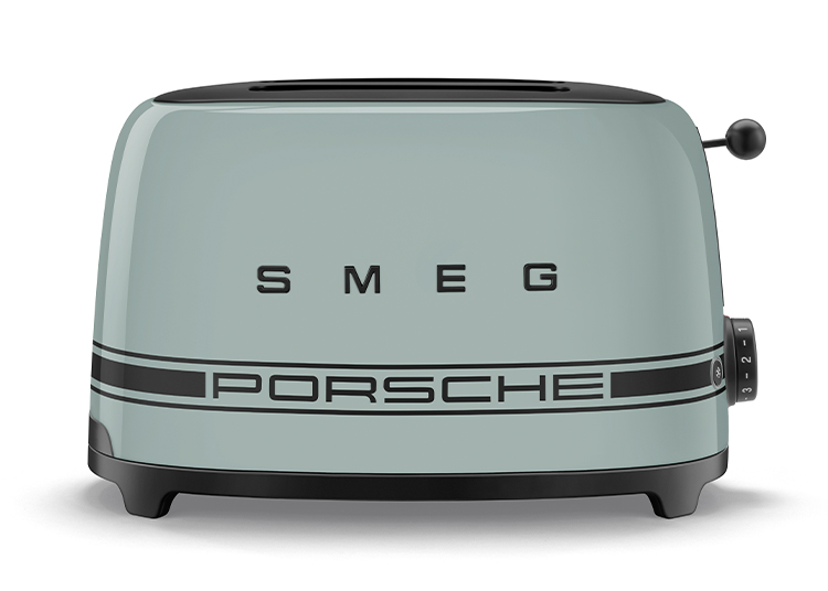 A pastel green SMEG toaster from the Kitchen Collection, featuring "PORSCHE" and a racing stripe on the front, with a numbered dial on the side.