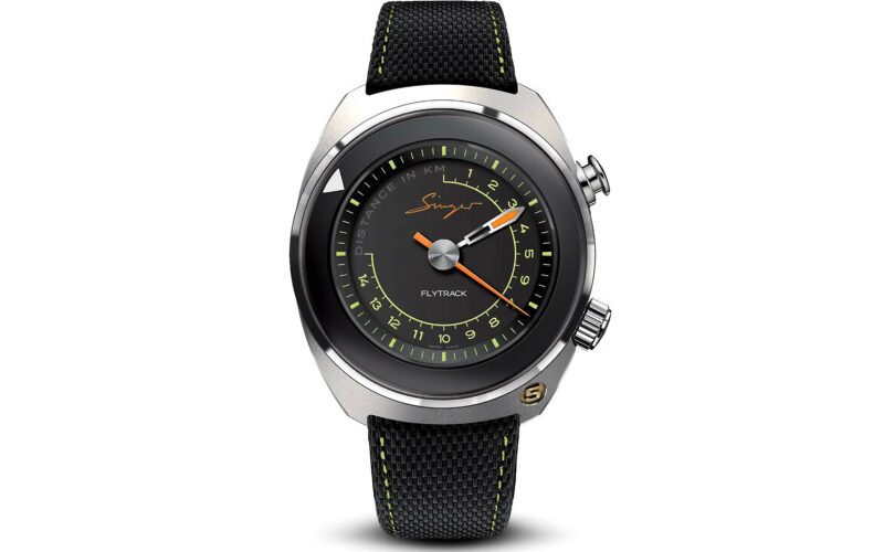 A round black and silver wristwatch with a black textured strap, yellow and orange accents, and two side buttons. The dial reads “Singer” and “Flytrack”—a striking addition to any collection of best luxury watches.