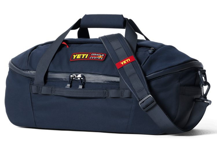 A navy blue YETI duffel bag with a shoulder strap and top handles, featuring a front zipper pocket and Yeti logo patches—a perfect companion for any Oracle Red Bull Racing or F1 enthusiast.