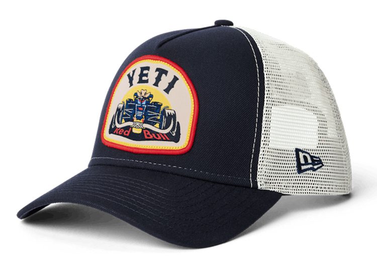 A navy blue and white mesh trucker cap featuring a "Yeti Red Bull" racing patch on the front, part of the Oracle Red Bull Racing F1 collection, with a New Era logo on the side.