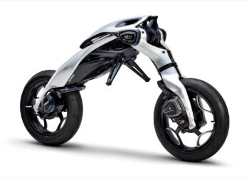 Futuristic, minimalist Yamaha MOTOROiDΛ electric motorcycle with exposed frame, two large wheels, and a sleek, aerodynamic white and black body design against a white background.