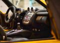 Close-up view of a luxury sports car interior featuring leather seats, a manual gear shift, and a modern dashboard with circular air vents and metallic accents—perfectly capturing the spirit of Pagani hypercars at Auto e Moto d'Epoca 2025.