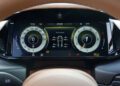Close-up of a digital car dashboard displaying speedometer, tachometer, tire pressures, warning lights, and driving information in the Review: 2025 Aston Martin Vanquish Coupe.