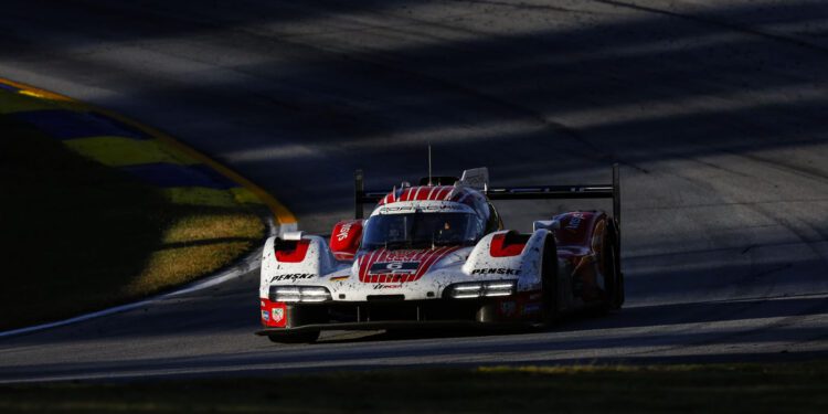 A red and white Porsche race car with visible dirt on the front drives on a sunlit section of the IMSA WeatherTech SportsCar racetrack, casting shadows in the background, embodying the thrill of 2025 motorsport.