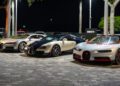Three Bugatti hypercars are parked side by side outdoors at night near a sign that reads "BUGATTI," with trees and lighting in the background, capturing an exclusive moment at Bugatti Broward.