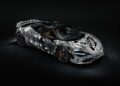 A black sports car with white geometric and graphic patterns, inspired by Project Viva Revealed: One-of-One McLaren 750S Spider Brings Las Vegas to Life, is parked in a dark studio setting.