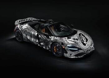 A black sports car with white geometric and graphic patterns, inspired by Project Viva Revealed: One-of-One McLaren 750S Spider Brings Las Vegas to Life, is parked in a dark studio setting.