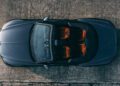 Overhead view of a dark convertible car with its top down, revealing four orange-brown seats, parked on a textured concrete surface—evoking the exclusivity of Bentley Honors Wartime Heroes with the Czech Squadron Collection and 2025 Remembrance Car.