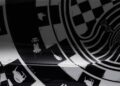Close-up of a surface featuring black and white geometric patterns, checkerboard designs, and stylized racing car illustrations, inspired by Project Viva Revealed: One-of-One McLaren 750S Spider Brings Las Vegas to Life.