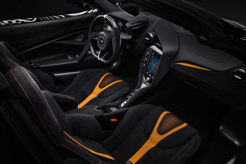Interior view of Project Viva Revealed: One-of-One McLaren 750S Spider brings Las Vegas to life with black and orange seats, a central touchscreen display, and a steering wheel equipped with digital dashboard controls.