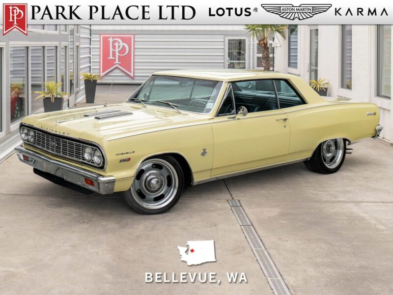 A vintage yellow Chevrolet Chevelle Malibu coupe, a standout among classic muscle cars, is parked outside a dealership in Bellevue, WA, with dealership branding visible at the top of the image.