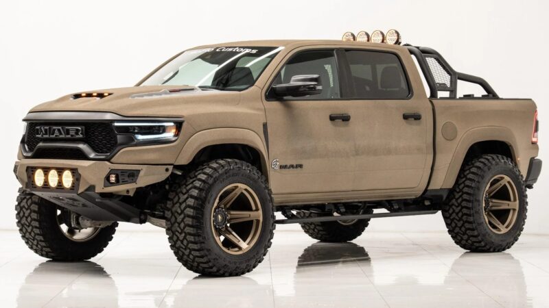 A matte tan off-road pickup truck with large tires, front-mounted lights, roof lights, and custom grille, blending impressive capability with the comfort expected from luxury trucks, shown on a white studio background.