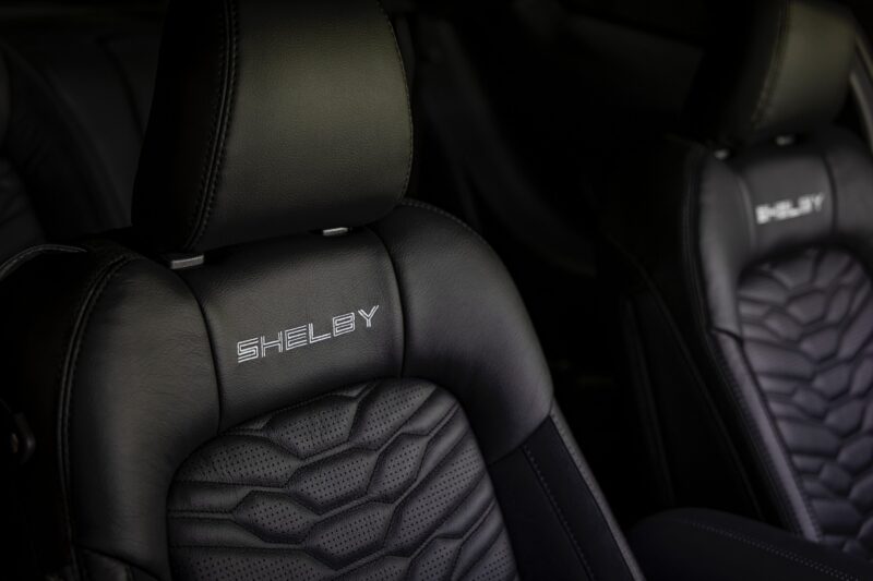 Close-up of black leather car seats with "SHELBY" embroidered on the headrest and detailed stitching on the seatbacks in the Review: 2025 Shelby GT350.