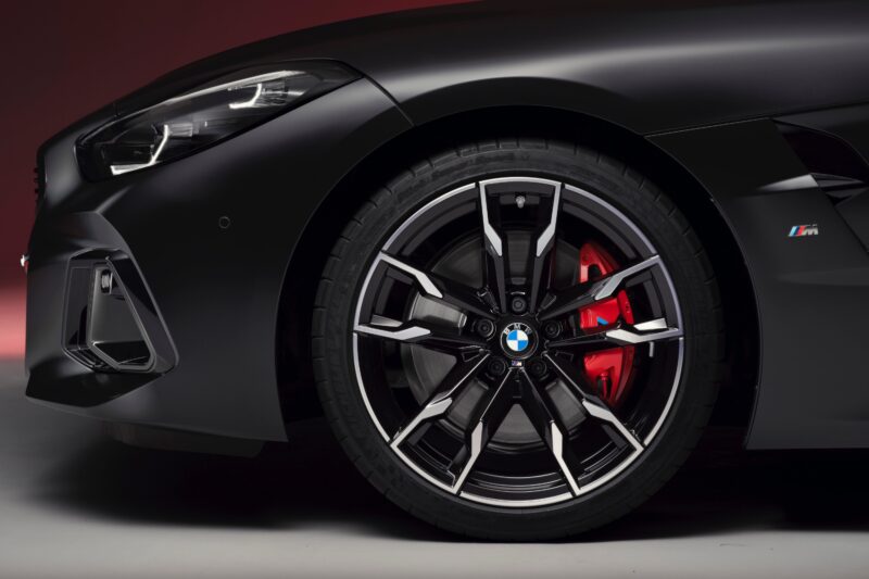 Close-up view of the End of the Road: 2026 BMW Z4 Final Edition Breaks Cover, featuring a black and silver alloy rim, red brake caliper, and part of the sleek black fender and headlight.