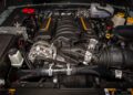 A close-up view of a car engine with various components, hoses, and fluid reservoirs under the hood—capturing details from the First of 12: Jeep Launches Its 85th Anniversary Limited Edition Series With the Moab 392.