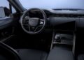 Modern car interior featuring a black steering wheel, digital instrument cluster, large central touchscreen, and minimalist dashboard design—reflecting the high-end style seen as Range Rover expands its 2026 Sport lineup with SV Black and SV Carbon Editions.