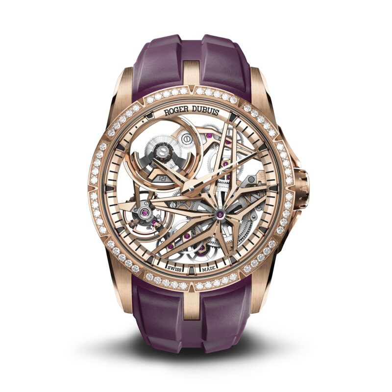 A rose gold skeleton watch with a diamond bezel, visible mechanical movement, and a purple rubber strap. The brand "Roger Dubuis" on the face makes it a standout among the best luxury watches.